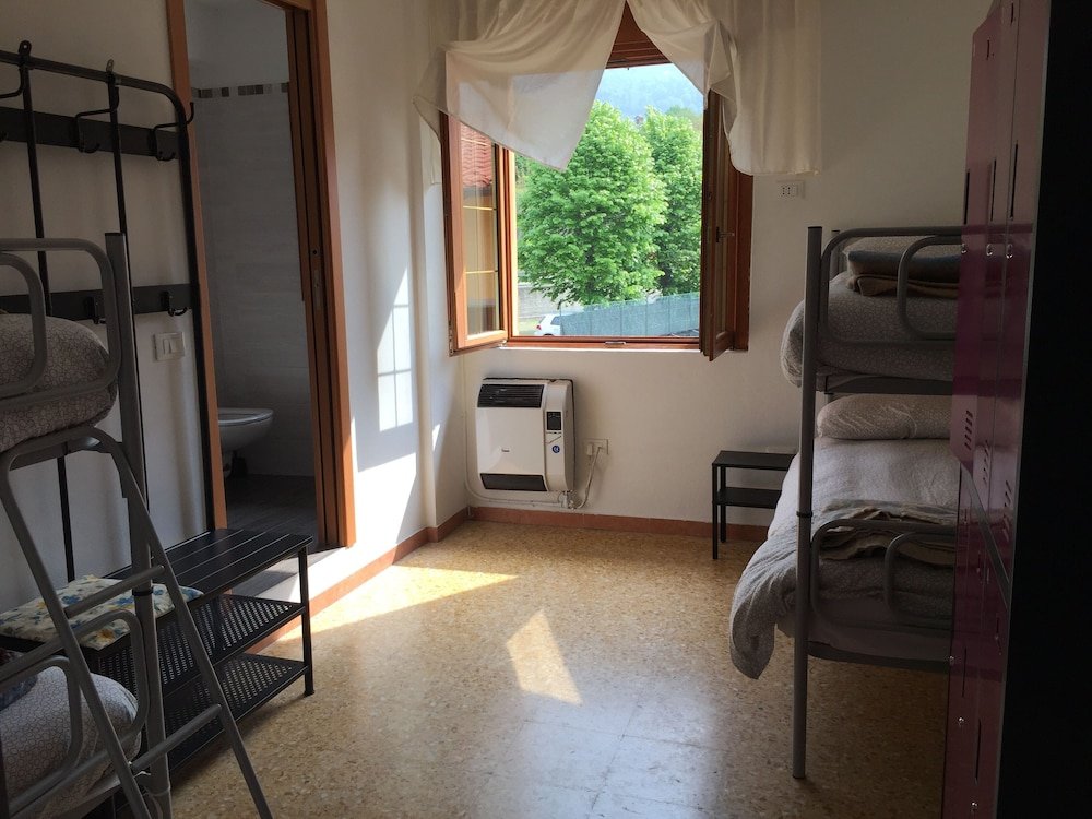 Cama en dormitorio compartido con vista al jardín Ostello Trentapassi