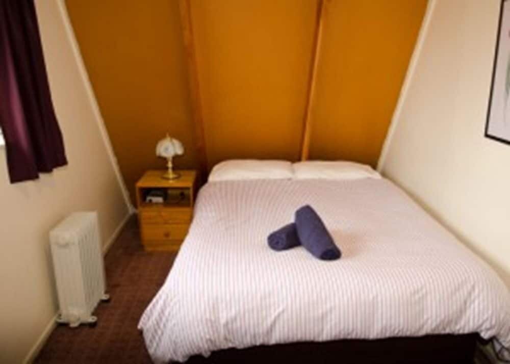 Кровать в общем номере Mountain Chalets Motel