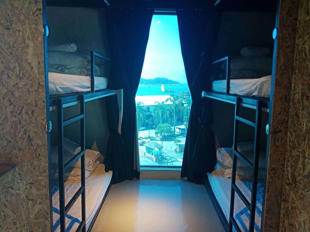 Кровать в общем номере с красивым видом из окна Homy Seafront Hostel