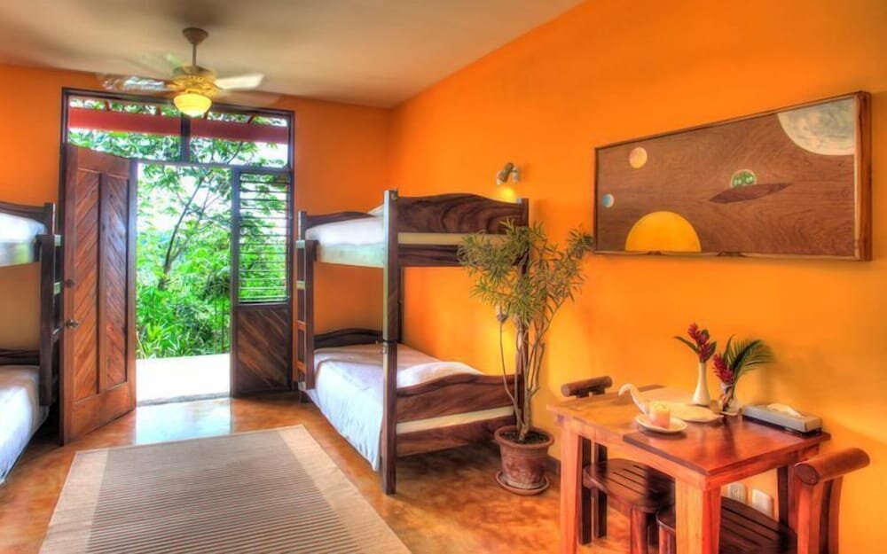 Cama en dormitorio compartido con balcón Costa Rica Yoga Spa