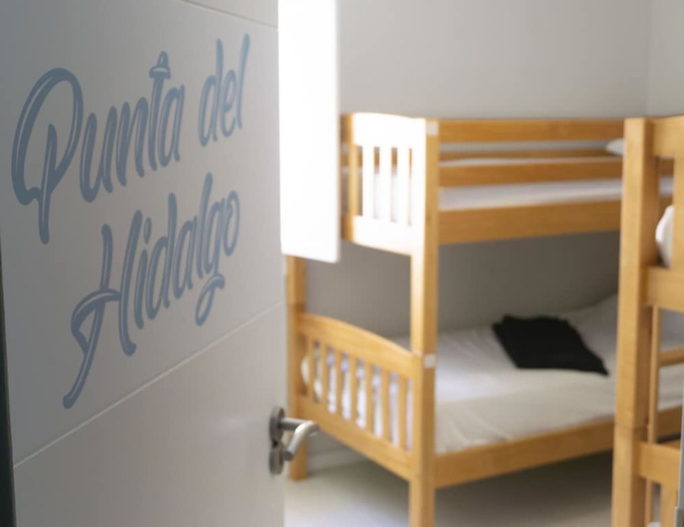 Cama en dormitorio compartido con balcón Tenerife Experience Hostel