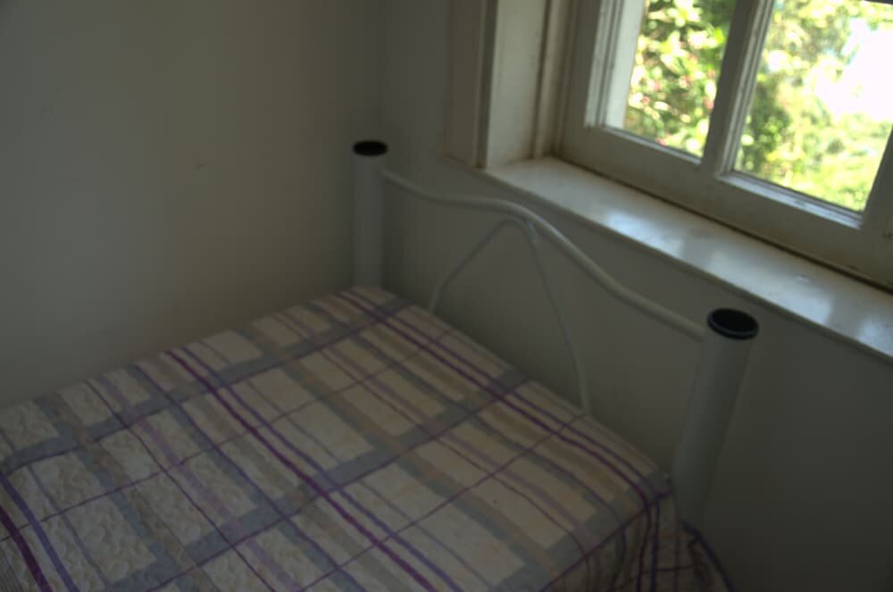 Cama en dormitorio compartido con vista Hostel Hill House