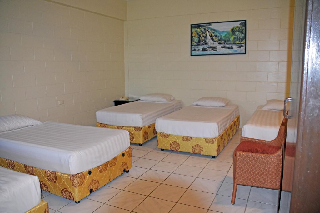 Кровать в общем номере с красивым видом из окна Grand Melanesian Hotel