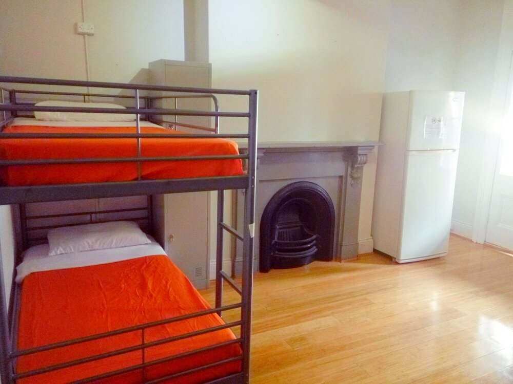 Cama en dormitorio compartido (dormitorio compartido femenino) con balcón Asylum Sydney Backpackers Hostel
