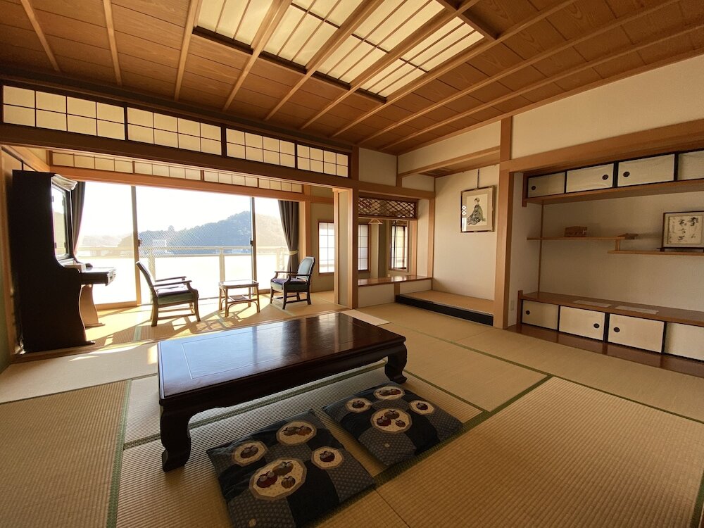 Кровать в общем номере с 6 комнатами с видом на океан Atami Onsen Guest House Megumi