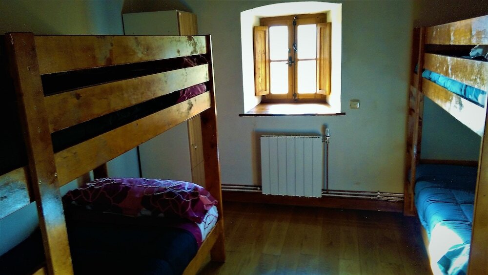 Cama en dormitorio compartido con balcón Albergue Rural Mandoia - Hostel