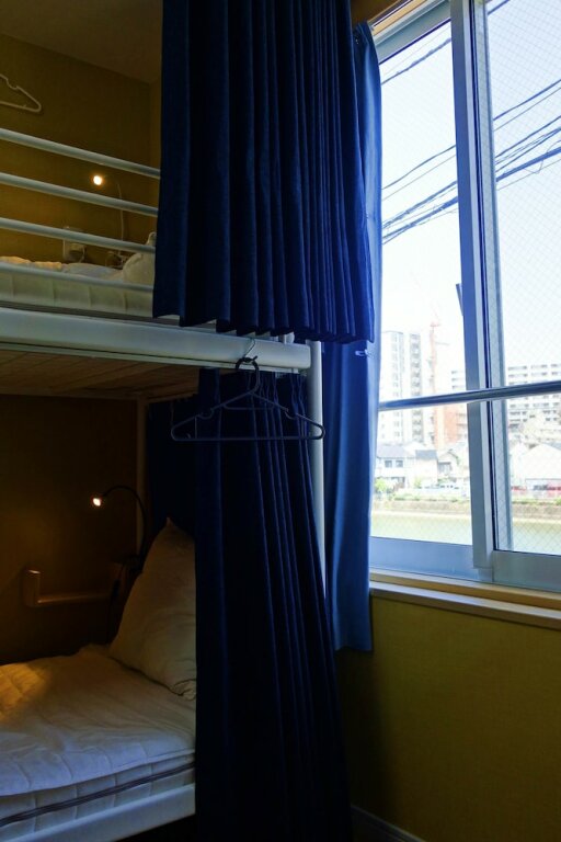 Cama en dormitorio compartido con vista al canal Fukuoka Tabiji Hostel & Guesthouse