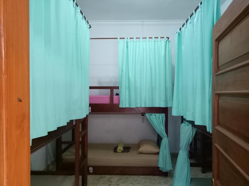 Кровать в общем номере Rumah Panjaitan