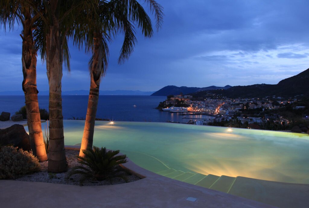 Cama en dormitorio compartido con vista al mar Hotel Villa Enrica Country Resort