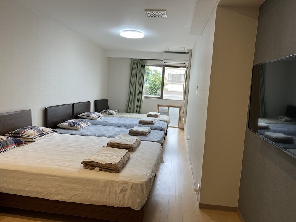 Кровать в общем номере с 6 комнатами с частичным видом на море Atami Onsen Guest House Megumi