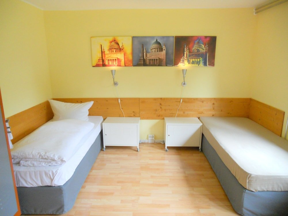 Cama en dormitorio compartido con vista al jardín Quartier SansSouci Hostel
