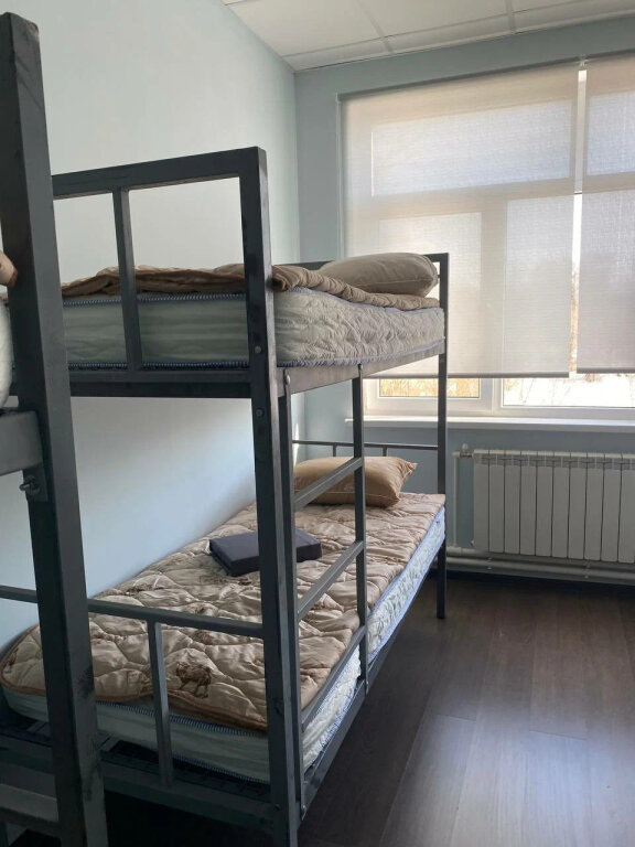 Cama en dormitorio compartido con vista Свои Люди Hostel