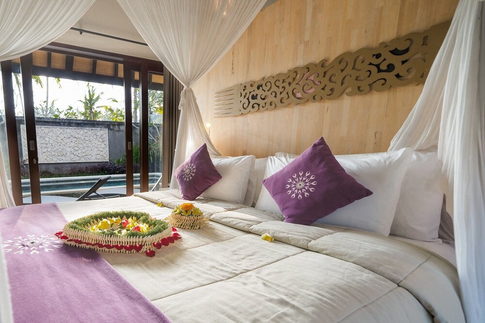 Suite 1 dormitorio con balcón y con vista al jardín Dedary Kriyamaha Ubud by Pramana Villa