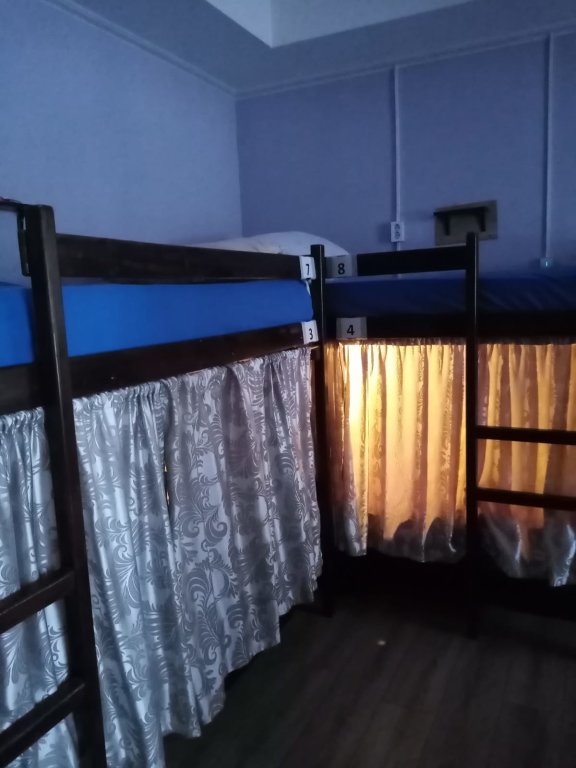 Cama en dormitorio compartido con vista Хостел REST